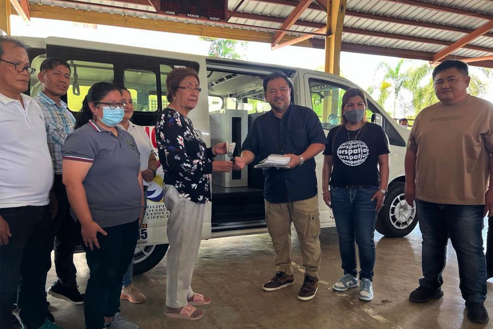 PCSO General Manager Mel A. Robles hands over the keys of an ambulance to Danglas Mayor Esther Bernos in simple ceremonies held at the Danglas, Abra covered court.