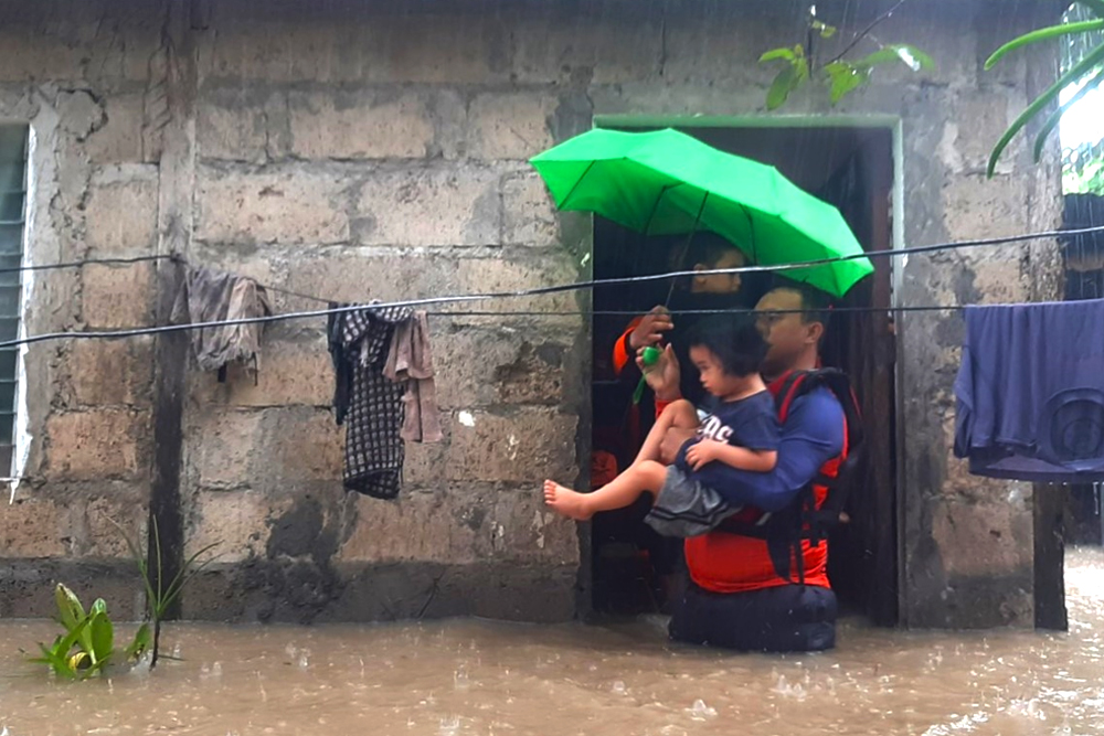 Phil. Coast Guard responders rescue family members that are stranded due to the flooding in Clarin town, Misamis Occidental on Dec. 25, 2022. (Photo courtesy of the Coast Guard District Northern Mindanao)