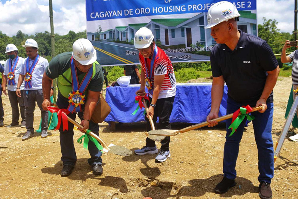 GROUNDBREAKING RITES – Cagayan de Oro City Mayor Rolando Uy (right) with National Housing Authority-10 Manager Alfonso Borlagdan (left), and Councilor Malvern Esparcia covering the hole where the time capsule for the San Simon Housing Project was placed. [Photo by Jomar Figuracion/CIO]