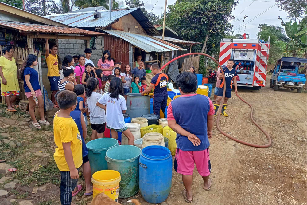 Residents of Sitio Laruk, Barangay Kisolon of Sumilao, Bukidnon waiting their empty water containers be filled with water from firetruck of their Municipal Fire Station, January 13, 2024. [Photo courtesy of BFP MFS Kisolon]