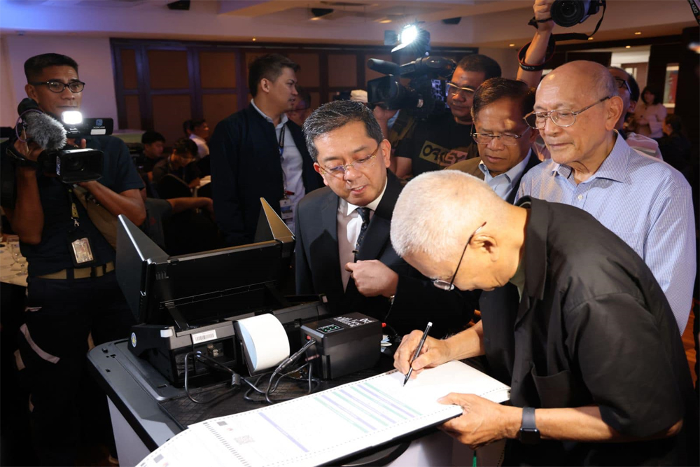 PROTOTYPE COUNTING MACHINES. Commission on Elections (Comelec) chairperson George Erwin Garcia (left) demonstrates the prototype of Miru System's automated counting machines (ACMs) for the 2025 national and local elections to a member of the Kapisanan ng mga Brodkaster ng Pilipinas during the KBP General Membership Meeting in Makati City on Tuesday (May 21, 2024). The Comelec earlier said the first 20 ACMs have passed the hardware acceptance test. (PNA photo by Yancy Lim)