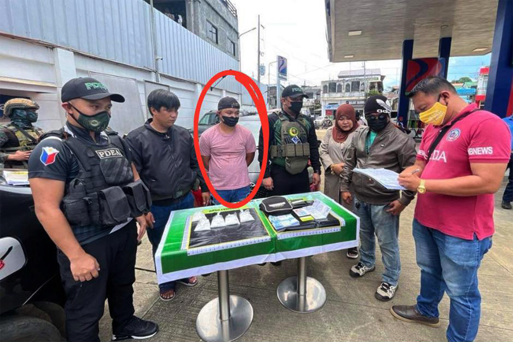 ENTRAPPED. Suspected drug peddler Arham Hadji Omar Alim (in handcuffs) looks on while a PDEA agent accounts for the shabu seized from him during a buy-bust in Marawi City on Wednesday (May 15, 2024). At least PHP3.4 million worth of the illegal drug substance was found in his possession. (Photo courtesy of PDEA-BARMM)