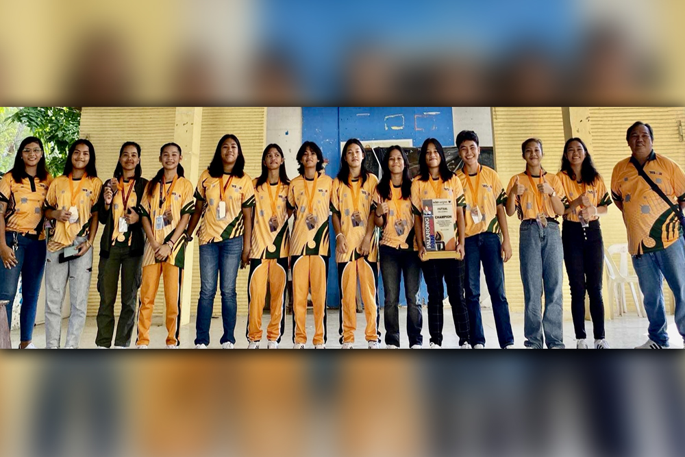 CHAMPION TEAM. Bulua National High School girls futsal team representing Cagayan De Oro Athletic Association (COAA) with coach Jun Actub (right) display their gold medals after arriving from Camiguin Province where they captured the championship in the High School Girls Futsal competition at the Sagay. Municipality gym. (Contributed photo)